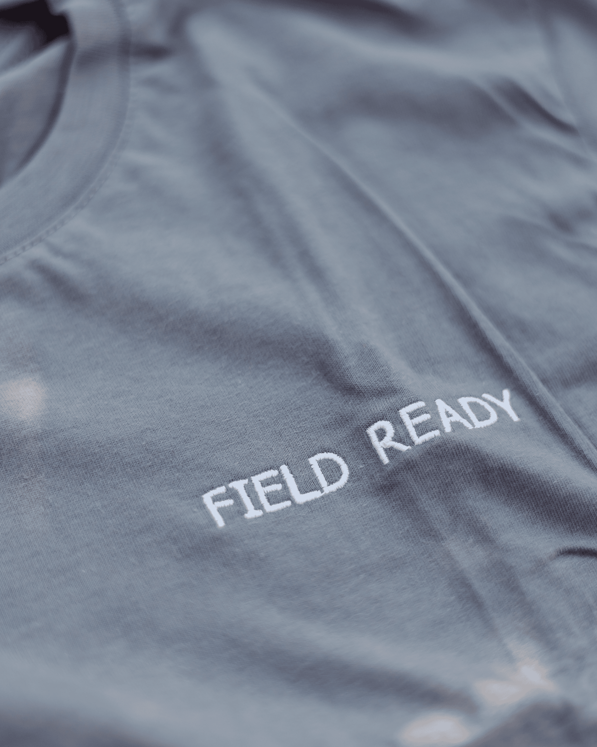 Gray shirt with 'FIELD READY' text on a close-up view